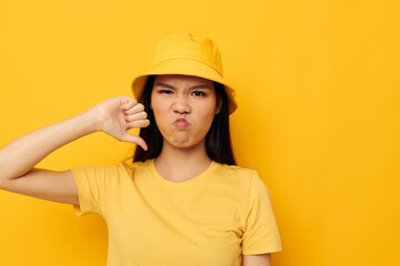 woman wearing a yellow hat posing emotions yellow background unaltered