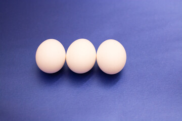 three white raw eggs lie on the table, photo large eggs. Preparing for Easter. Easter Ingredients