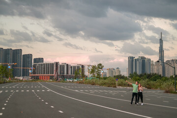 Lovely young couple walking on the street in the big city on the sunset. Boyfriend and girlfriend. Love and happiness. Skyscrapers on the background