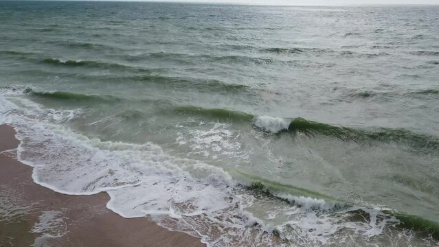 Stormy wavy sea coast beach with green water azov sea