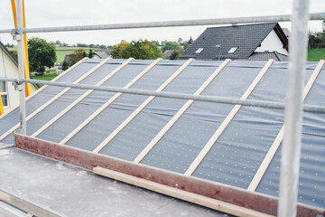 New build house roof with plastic sheeting for waterproofing