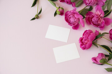 Blank branding paper card sheet with mockup copy space and elegant peonies flowers on pink background. Aesthetic flowers composition