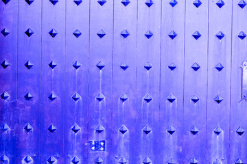 Wood purple texture old facade violet fence natural background wooden with nails and metal spikes blue horizontal