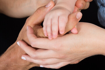 Close-up of baby fingers hand on  parent mother father finger hands