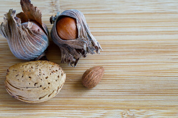 Hazelnuts and almonds close-up on a wooden surface.