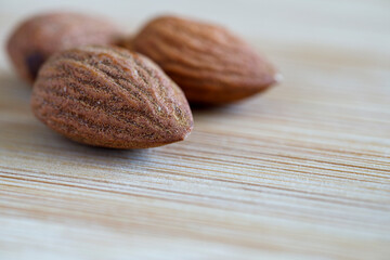 Almond nuts in close-up on a wooden surface.