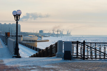 City granite embankment on a winter morning. Street lamp and descent to the river. Cranes of the...