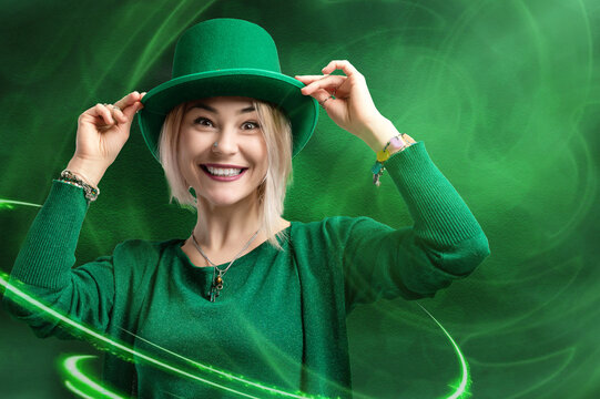 St. Patrick's Day leprechaun model girl on green magic background with shamrock leaves