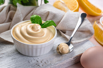 Mayonnaise with a white bowl with basil close-up. Side view.