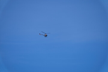 Small Helicopter flying against the blue sky