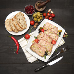Sliced Traditional French terrine covered with bacon on dark wooden background