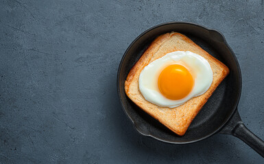Toast with fried eggs on a graphite background. Top view, horizontal. Space for copying.
