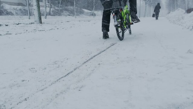 The bicycle with winter studded tire stops abruptly on the snow-covered street. Concept of winter cycling safety. Finland.