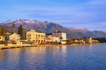 Beautiful Mediterranean landscape on sunny winter day.   Montenegro. View of Tivat city and snow-capped Lovcen mountain