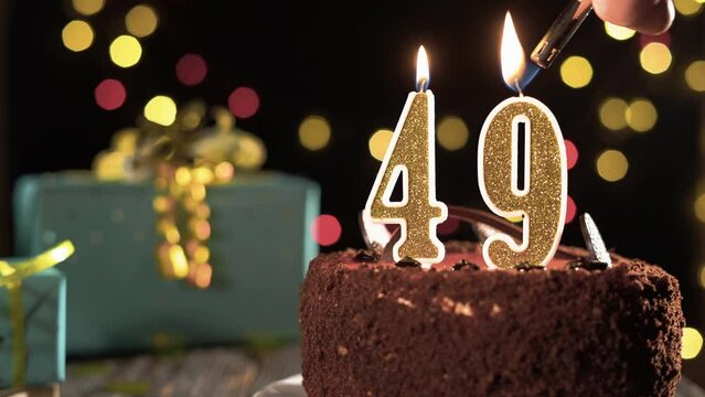 Birthday candle number forty nine one on a sweet cake on the table, 49th birthday. Fire from the lighter, blow out the holiday candle.
