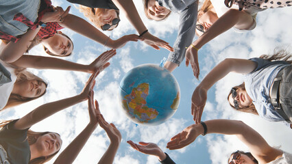 Earth conservation concept. 11 girls surround the rotating earth globe with their palms hands.