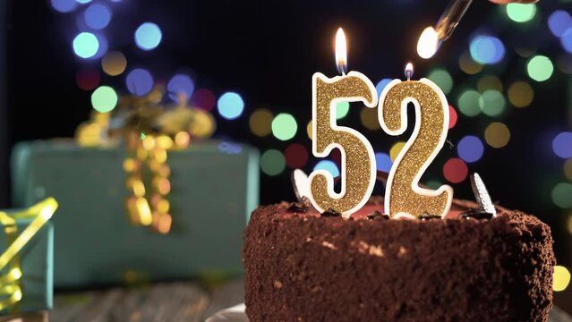 Birthday candle number fifty two one on a sweet cake on the table, 52nd birthday. Fire from the lighter, blow out the holiday candle.