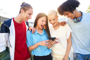  Gen Z young students using smartphone and social networks together. Multiracial people having fun...
