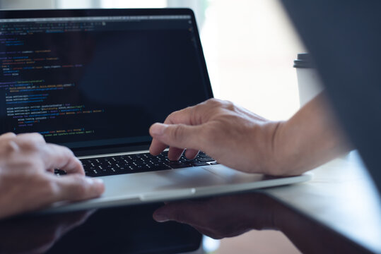 Web or application development, business and technology concept. Programmer, man software engineer, app developer hands coding HTML, programming Javascript on laptop computer