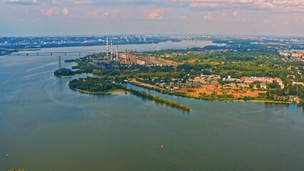 Photo from a drone of a beautiful summer landscape over the river. Beautiful summer landscape with a wide river and green coastline. Aerial photography of the suburban landscape.