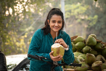 Young woman drinking coconut water after workout