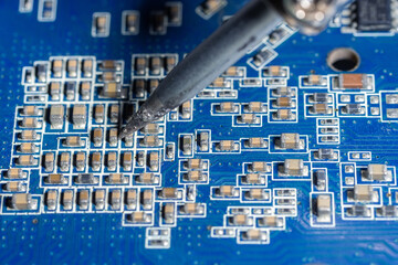 Repairman is soldering the motherboard of electronic device..