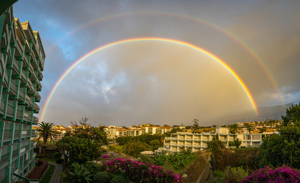 Panorama of a vibrant double rainbow over Puerto de la Cruz, Tenerife in the evening.