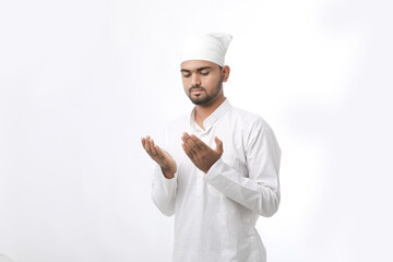 Indian muslim religious man praying on white background.