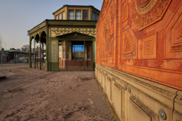 Orange wall. Octagonal building on an orange wall. Facade with arc and windows. Main entrance of...