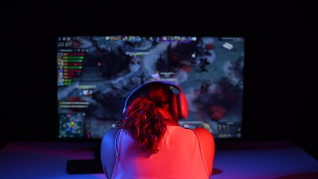 Caucasian woman upset after losing a computer game in neon light in the dark.