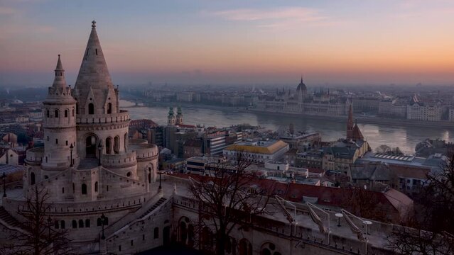 Night to day sunrise time lapse view of the Fisherman's Bastion (Halaszbastya) with Hungarian Parliament building and River Danube at background