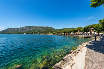 Promenade in Garda downtown along the lakeshore, village and tourist resort on the coast of Lake Garda (Lago di Garda). Verona province, Veneto, Italy, Europe. On horizon the Promontory of San Vigilio