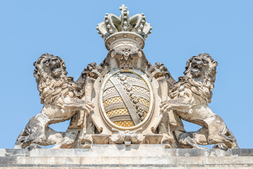 Ancient decoration element of two scary lions protecting a king coat of arms, shield and crone in downtown historical center of Dresden, Germany, summer, closeup, details.