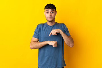 Young Colombian man isolated on yellow background making the gesture of being late