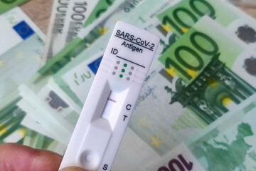 Coronavirus rapid antigen test with euro banknotes. Corona virus SARS-Cov-2 fast negative test....