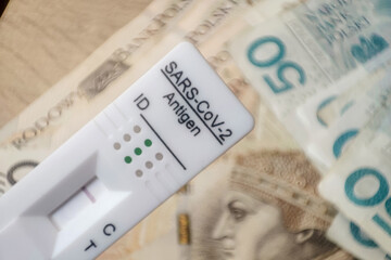 Coronavirus rapid antigen test with polish PLN banknotes. Corona virus SARS-Cov-2 fast negative test. test cassette on several euro banknotes background
