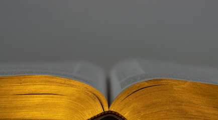 Close up of a old open book with golden pages, focus on foreground and copy space