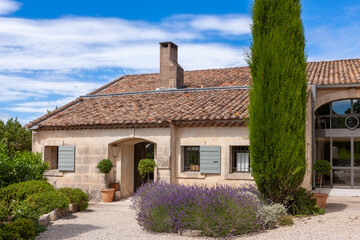 Fototapeta na wymiar A house with a tiled roof and lavender with cypress is a typical picture in Provence, France