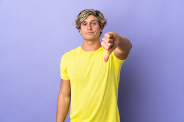 English man over isolated purple background showing thumb down with negative expression