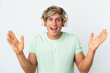 English man over isolated white background surprised and listening music