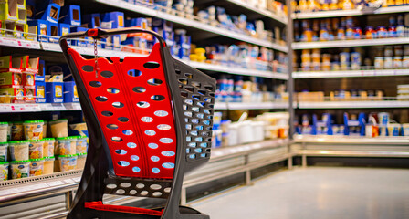 A shopping cart with grocery products in a supermarket