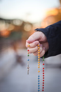 Joven rezando el rosario por la paz en el mundo. Santo Rosario de colores o de los continentes. Rosario de la Virgen de F&aacute;tima.