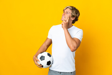 English football player over isolated yellow background thinking an idea while looking up