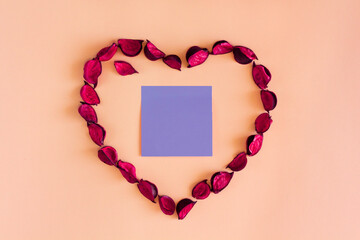 Heart of red petals on coral background. Beautiful frame in shape of heart. Floral template for design to Valentine's Day, anniversary, wedding