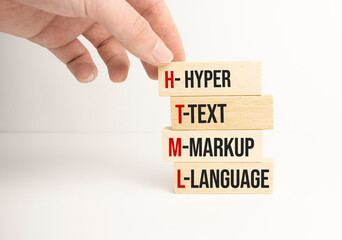 Closeup man add more some alphabets wood cubes into the row to complete the word html, converge...