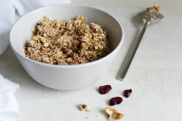 The process of making energy bars at home. Ready mix of ground ingredients in a gray bowl on a light background. Healthy food concept. Selective focus.