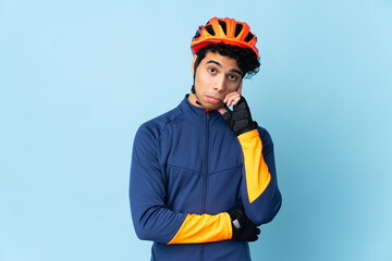 Venezuelan cyclist man isolated on blue background thinking an idea