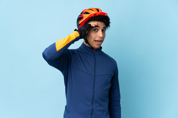 Venezuelan cyclist man isolated on blue background doing surprise gesture while looking to the side - obrazy, fototapety, plakaty