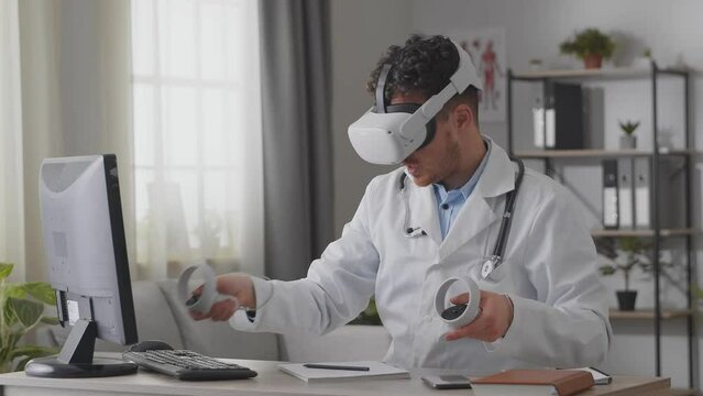 Man doctor working in hospital office using virtual reality technology. VR masterclass