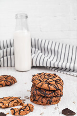 Fresh chip cookies and milk bootle ona a white table. Breakfast concept. Side view.